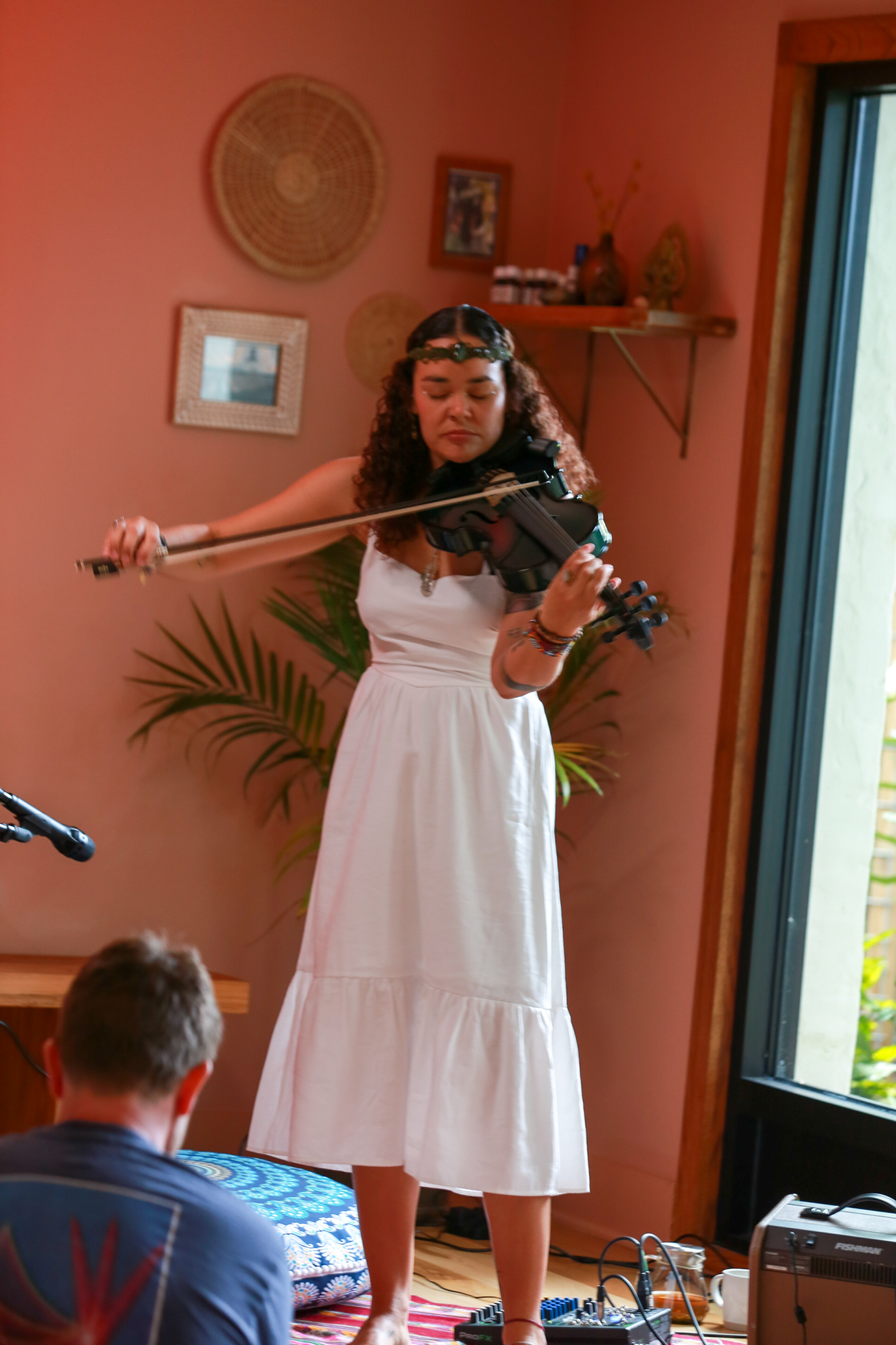 Sisy Jamaraam performing on viola in a flowing white dress.