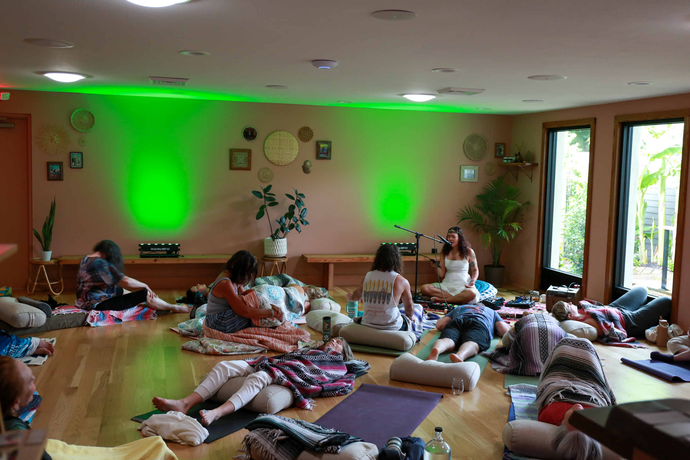 A Root to Crown gathering with participants resting on cushions as Sisy guides the live sound journey.